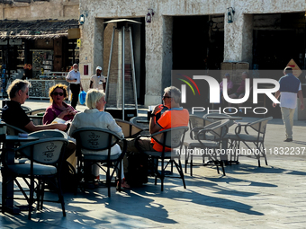 People sit outside a cafe in Downtown in the afternoon in Doha, Qatar, on December 03, 2024. (