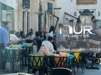 People sit outside a cafe in Downtown in the afternoon in Doha, Qatar, on December 03, 2024. (