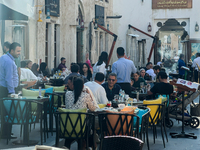 People sit outside a cafe in Downtown in the afternoon in Doha, Qatar, on December 03, 2024. (