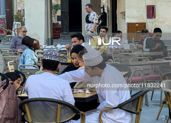 People sit outside a cafe in Downtown in the afternoon in Doha, Qatar, on December 03, 2024. 