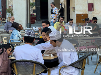 People sit outside a cafe in Downtown in the afternoon in Doha, Qatar, on December 03, 2024. (