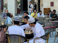 People sit outside a cafe in Downtown in the afternoon in Doha, Qatar, on December 03, 2024. (