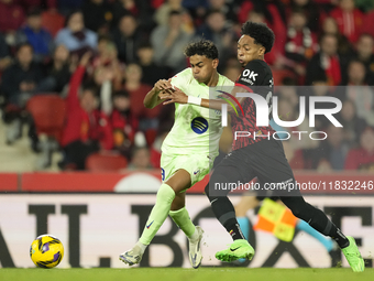 Lamine Yamal right winger of Barcelona and Spain and Johan Mojica left-back of Mallorca and Colombia compete for the ball during the La Liga...