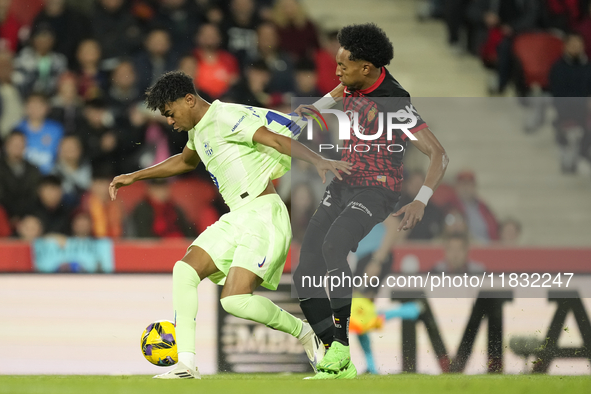 Lamine Yamal right winger of Barcelona and Spain and Johan Mojica left-back of Mallorca and Colombia compete for the ball during the La Liga...