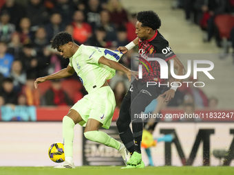 Lamine Yamal right winger of Barcelona and Spain and Johan Mojica left-back of Mallorca and Colombia compete for the ball during the La Liga...