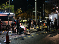 Media outlets prepare their reports outside the main gate of the National Assembly in Seoul, South Korea, on December 4, 2024, forming a hum...