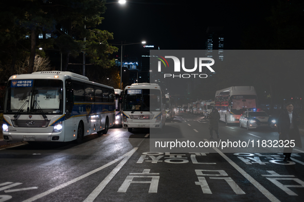 Police buses station outside the main gate of the National Assembly in Seoul, South Korea, on December 4, 2024, forming a human barricade to...