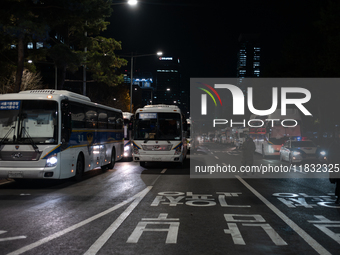 Police buses station outside the main gate of the National Assembly in Seoul, South Korea, on December 4, 2024, forming a human barricade to...