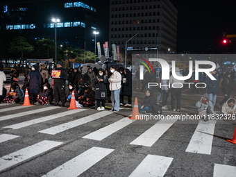 Citizens block the road in front of the National Assembly's main gate in Seoul, South Korea, on December 4, 2024, forming a human barricade...