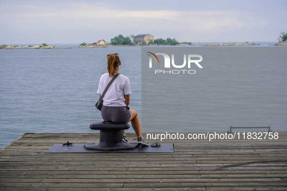 A single lady sits on the pier looking at the sea in Karlskrona, Sweden, on August 15, 2024. 