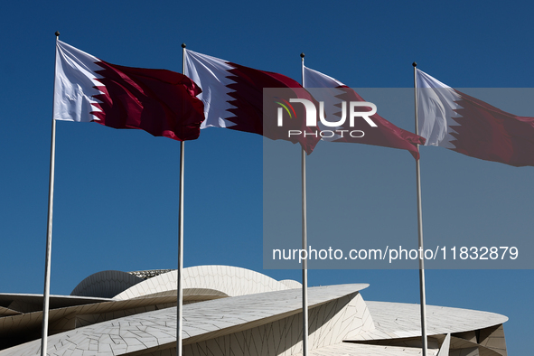 Flags of Qatar are seen near the National Museum of Qatar in Doha, Qatar on December 3, 2024. 