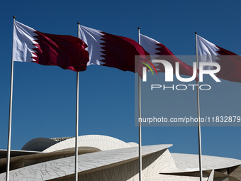 Flags of Qatar are seen near the National Museum of Qatar in Doha, Qatar on December 3, 2024. (