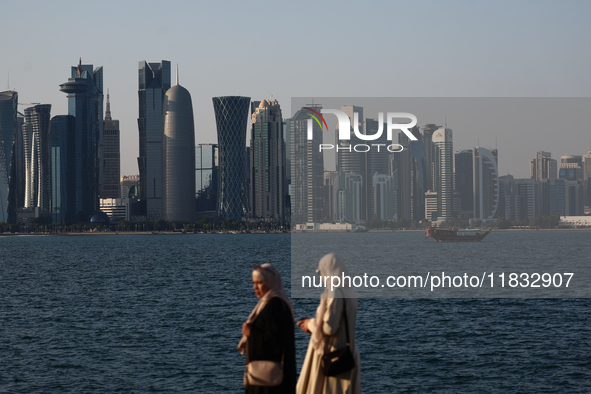 Women wearing traditional dress are seen with the city and Doha Bay in Doha, Qatar on December 3, 2024. 