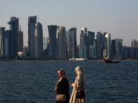 Women wearing traditional dress are seen with the city and Doha Bay in Doha, Qatar on December 3, 2024. (