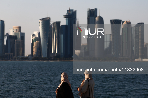 Women wearing traditional dress are seen with the city and Doha Bay in Doha, Qatar on December 3, 2024. 