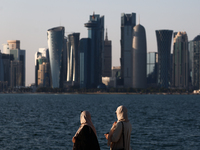 Women wearing traditional dress are seen with the city and Doha Bay in Doha, Qatar on December 3, 2024. (