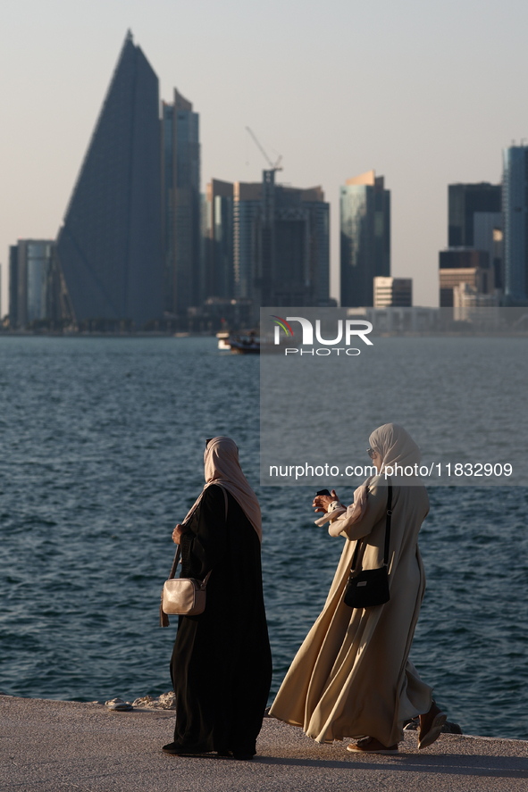 Women wearing traditional dress are seen with the city and Doha Bay in Doha, Qatar on December 3, 2024. 