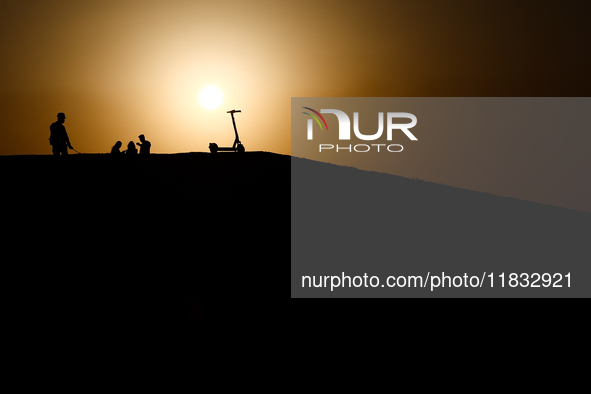 People and a scooter are seen in Doha, Qatar on December 3, 2024. 