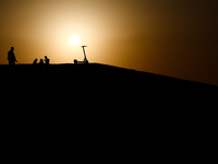 People and a scooter are seen in Doha, Qatar on December 3, 2024. (