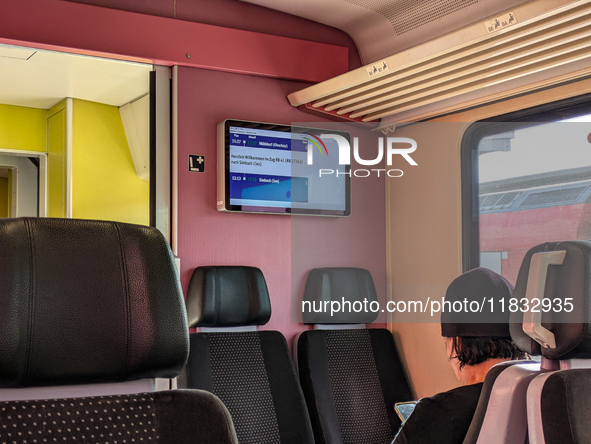 Inside a Deutsche Bahn train compartment near Mühldorf, Bavaria, Germany, on October 6, 2024, a passenger sits in a modern, comfortable seat...