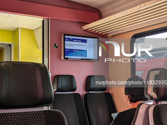 Inside a Deutsche Bahn train compartment near Mühldorf, Bavaria, Germany, on October 6, 2024, a passenger sits in a modern, comfortable seat...