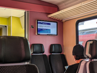 Inside a Deutsche Bahn train compartment near Mühldorf, Bavaria, Germany, on October 6, 2024, a passenger sits in a modern, comfortable seat...