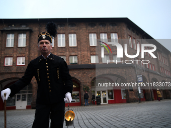 A miner with a lamp participates in the traditional waking up of residents during Barborka in Nikiszowiec, Poland, on December 4, 2024. Barb...