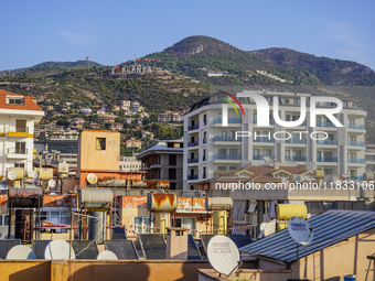 A general view of the dense city development with visible roofs full of solar installations for heating water is seen in Alanya, Antalya, Tu...