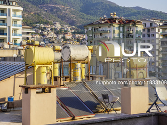 A general view of the dense city development with visible roofs full of solar installations for heating water is seen in Alanya, Antalya, Tu...