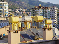 A general view of the dense city development with visible roofs full of solar installations for heating water is seen in Alanya, Antalya, Tu...