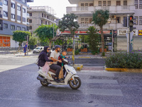 A family of three rides on a moped by the main street of the city in Alanya, Antalya, Turkey, on November 3, 2024. (