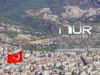 A general aerial view of the dense urban development with a Turkish flag visible in the wind is seen in Alanya, Antalya, Turkey, on November...