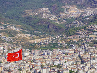 A general aerial view of the dense urban development with a Turkish flag visible in the wind is seen in Alanya, Antalya, Turkey, on November...