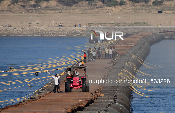 Labourers build a floating pontoon bridge at Sangam, the confluence of the rivers Ganges, Yamuna, and Saraswati, in Prayagraj, India, on Dec...