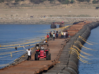 Labourers build a floating pontoon bridge at Sangam, the confluence of the rivers Ganges, Yamuna, and Saraswati, in Prayagraj, India, on Dec...