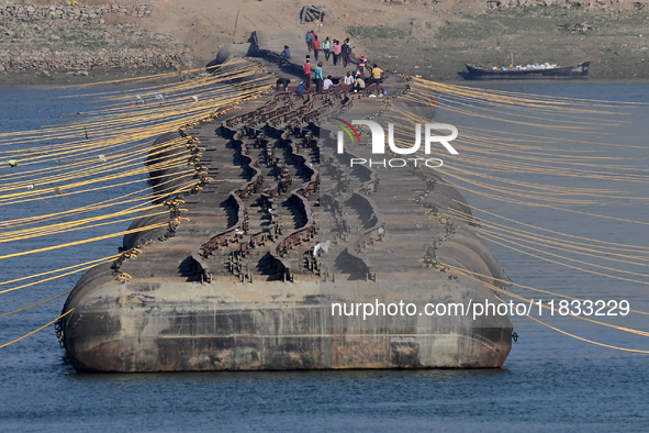 Labourers build a floating pontoon bridge at Sangam, the confluence of the rivers Ganges, Yamuna, and Saraswati, in Prayagraj, India, on Dec...