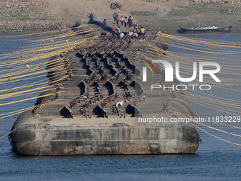 Labourers build a floating pontoon bridge at Sangam, the confluence of the rivers Ganges, Yamuna, and Saraswati, in Prayagraj, India, on Dec...