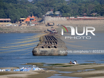 Labourers build a floating pontoon bridge at Sangam, the confluence of the rivers Ganges, Yamuna, and Saraswati, in Prayagraj, India, on Dec...