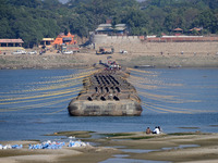 Labourers build a floating pontoon bridge at Sangam, the confluence of the rivers Ganges, Yamuna, and Saraswati, in Prayagraj, India, on Dec...