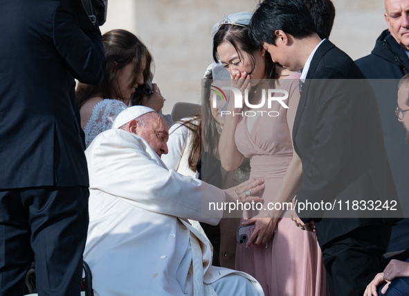 Pope Francis blesses a pregnant woman during his weekly general audience in St. Peter's Square at The Vatican, on December 4, 2024. 