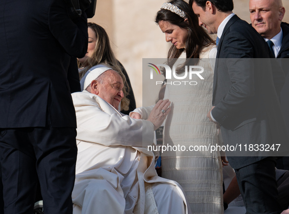 Pope Francis blesses a pregnant woman during his weekly general audience in St. Peter's Square at The Vatican, on December 4, 2024. 