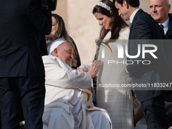 Pope Francis blesses a pregnant woman during his weekly general audience in St. Peter's Square at The Vatican, on December 4, 2024. (