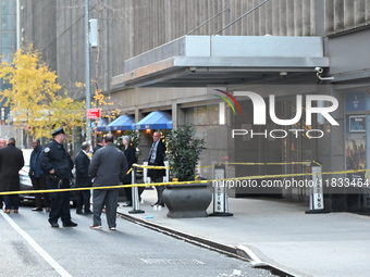 Police cover evidence with paper cups as as CEO of UnitedHealthcare Brian Thompson, 50, was shot as he entered the New York Hilton after 6:4...