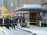 Police cover evidence with paper cups as as CEO of UnitedHealthcare Brian Thompson, 50, was shot as he entered the New York Hilton after 6:4...