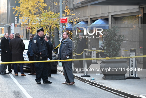 Police cover evidence with paper cups as as CEO of UnitedHealthcare Brian Thompson, 50, was shot as he entered the New York Hilton after 6:4...