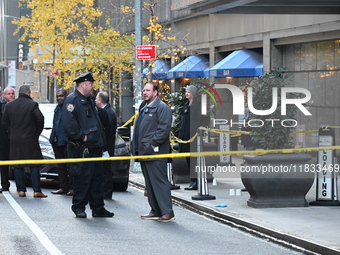 Police cover evidence with paper cups as as CEO of UnitedHealthcare Brian Thompson, 50, was shot as he entered the New York Hilton after 6:4...