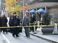 Police cover evidence with paper cups as as CEO of UnitedHealthcare Brian Thompson, 50, was shot as he entered the New York Hilton after 6:4...