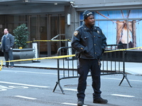 Police cover evidence with paper cups as as CEO of UnitedHealthcare Brian Thompson, 50, was shot as he entered the New York Hilton after 6:4...