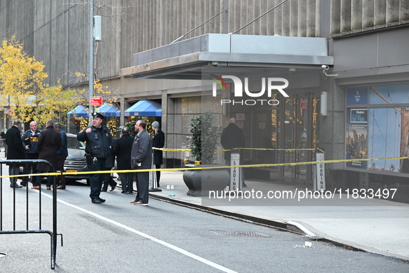 Police cover evidence with paper cups as as CEO of UnitedHealthcare Brian Thompson, 50, was shot as he entered the New York Hilton after 6:4...