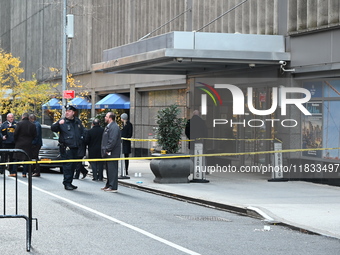 Police cover evidence with paper cups as as CEO of UnitedHealthcare Brian Thompson, 50, was shot as he entered the New York Hilton after 6:4...